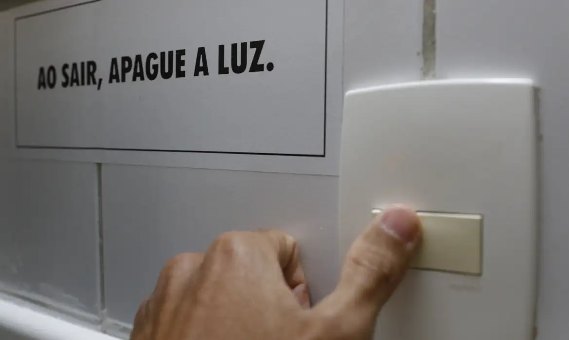 「出かける時は電気を消して」と呼びかける張り紙（© Fernando Frazão/Agência Brasil）