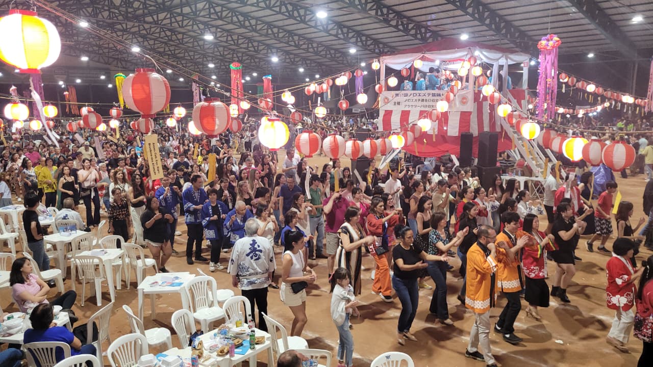 Cena do festival Bon Odori do Noroeste com milhares de pessoas dançando em círculo