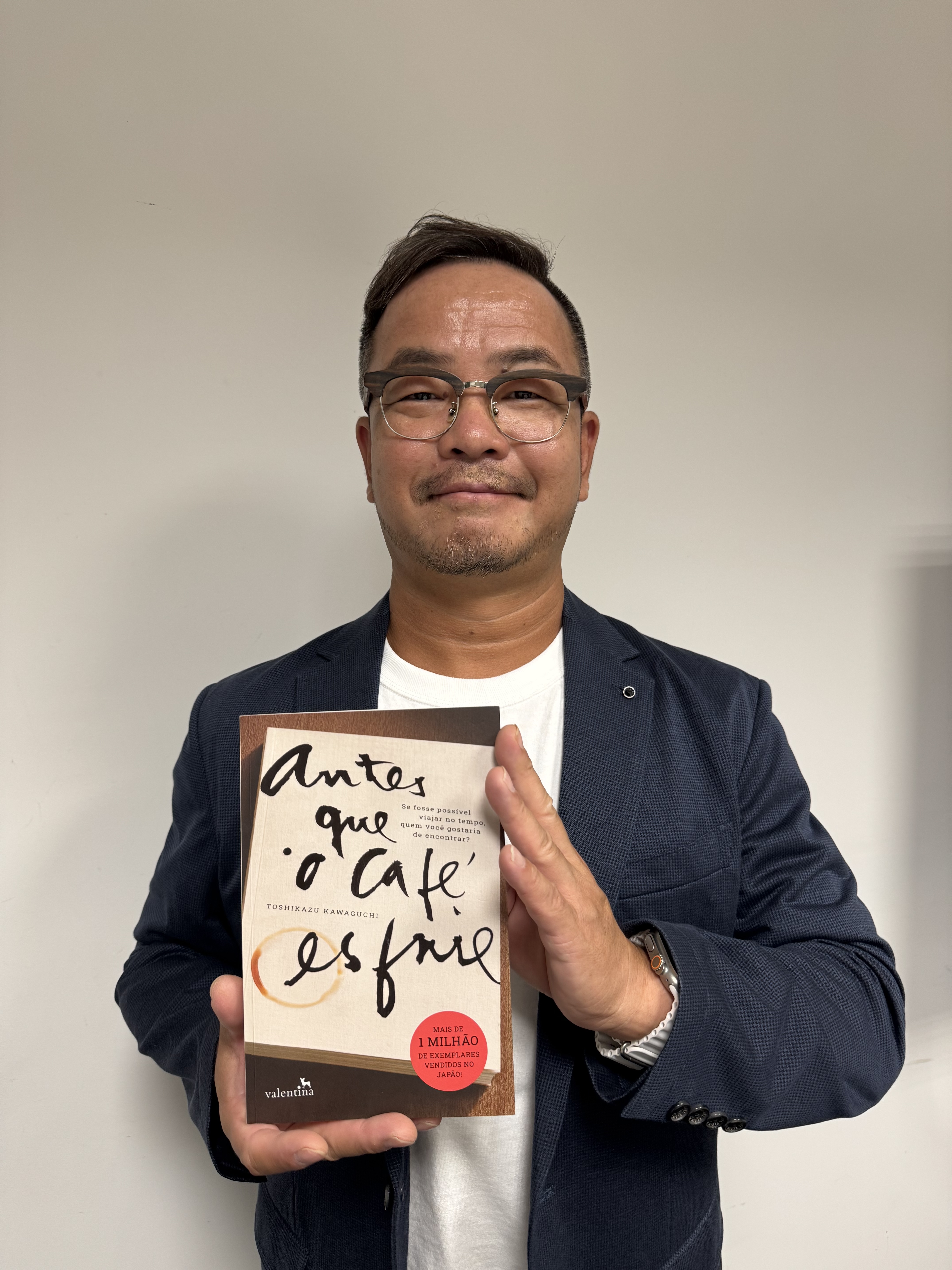 著書『コーヒーが冷めないうちに』のポルトガル語版を手にもつ川口俊和さん