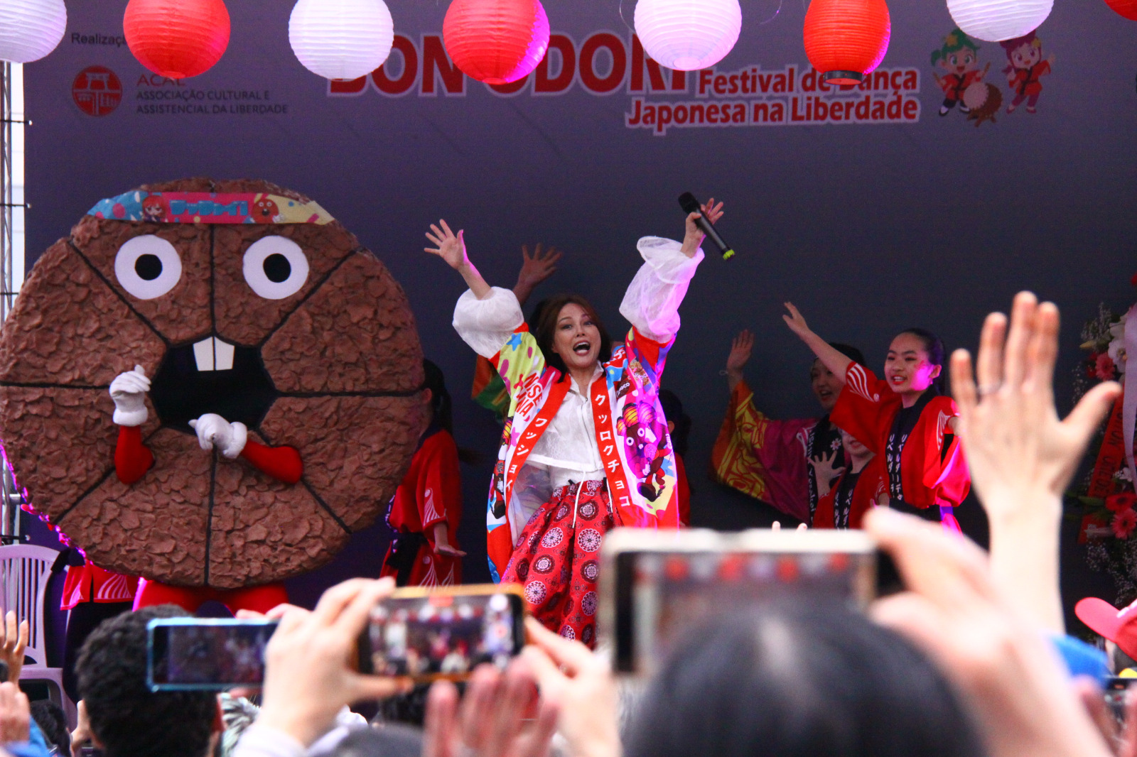 新曲『ワッショイ！』で両手を上げて歓声に応える相川七瀬氏（中央）