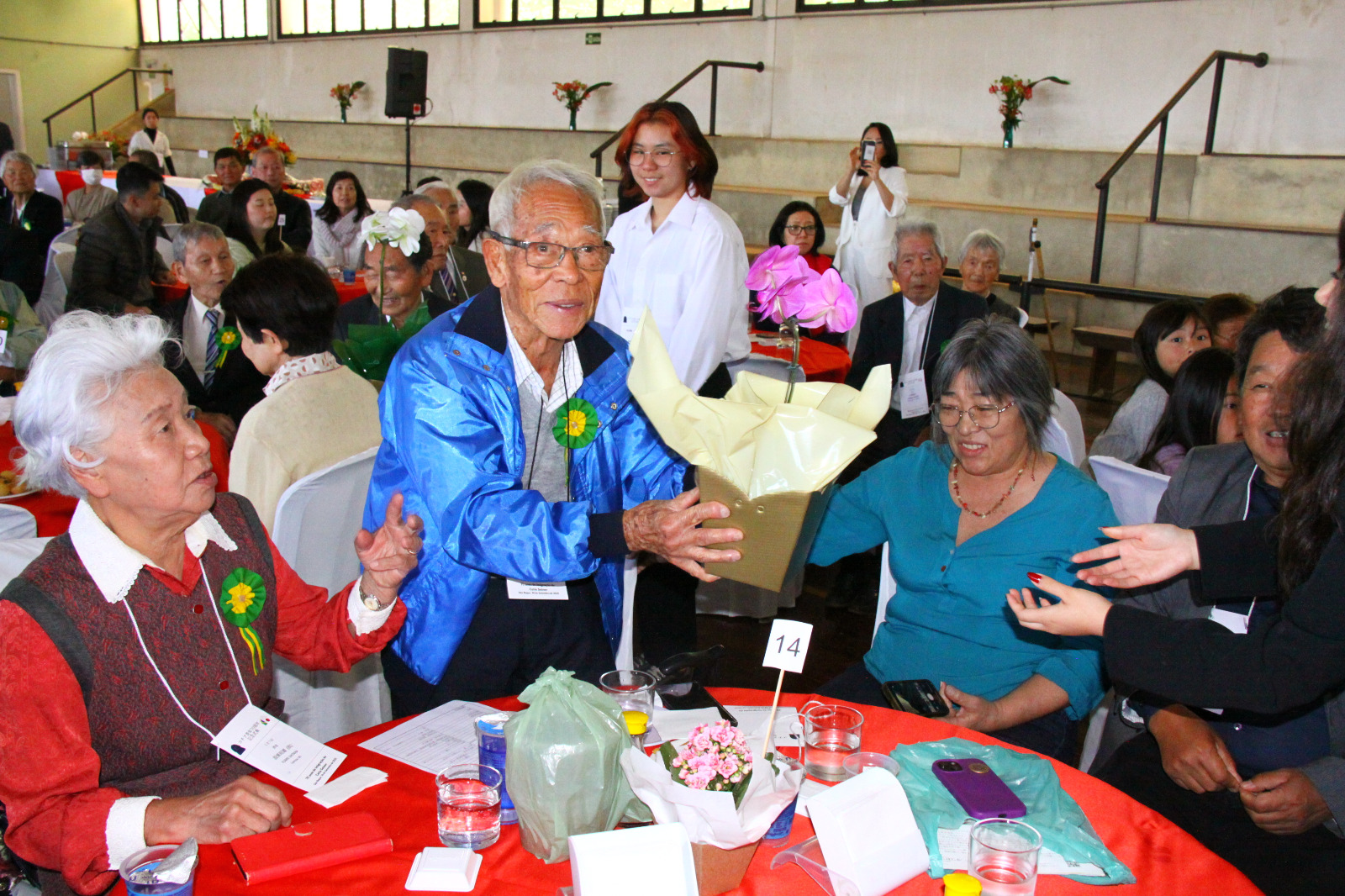 卒寿祝いのランの花を贈呈された村田勇さん。その左は設楽文枝さん