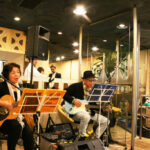 大阪市内の老舗喫茶店「マヅラ」で歌う「くるみの樹」の２人。左から、やまのはさん、国谷さん（１０月１０日撮影）