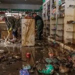 浸水被害後の店を掃除する人々（©Rafa Neddemeyer/Agencia Brasil）